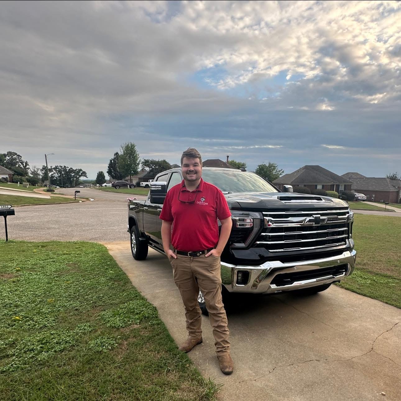 Jarrod Castleberry standing in a red Castle Foam polo in front of his black truck
